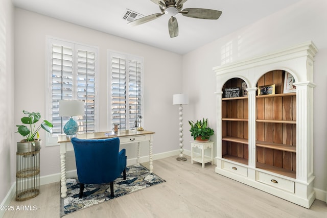 office featuring a ceiling fan, visible vents, baseboards, and wood finished floors