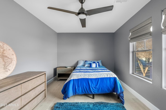 bedroom featuring a ceiling fan, baseboards, and wood finished floors