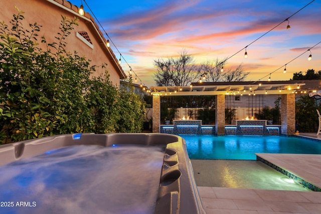 outdoor pool with a hot tub, fence, and a patio