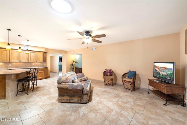 living area with a ceiling fan and visible vents
