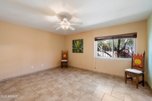 spare room featuring baseboards and ceiling fan