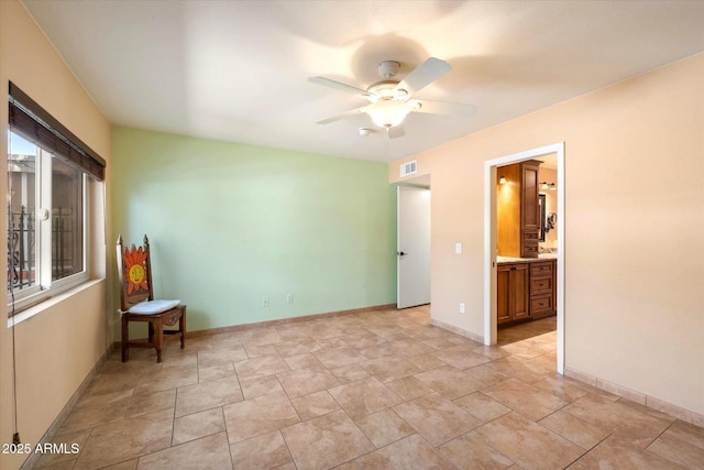 unfurnished bedroom featuring baseboards, a ceiling fan, visible vents, and connected bathroom