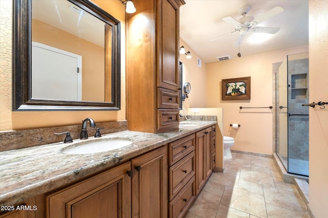full bathroom featuring a sink, toilet, a ceiling fan, double vanity, and a shower with shower door