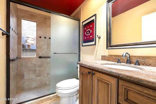 full bathroom with a tile shower, vanity, and toilet