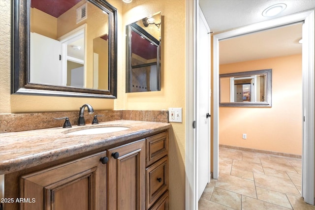 bathroom with vanity, visible vents, and baseboards