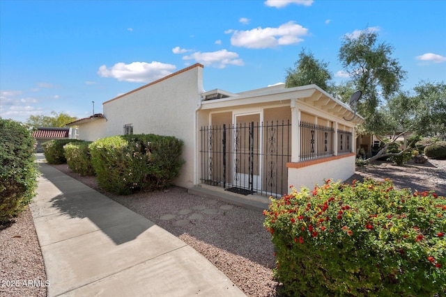 view of property exterior with stucco siding and a fenced front yard