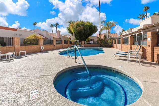 community pool featuring fence, a patio, a residential view, and a community hot tub