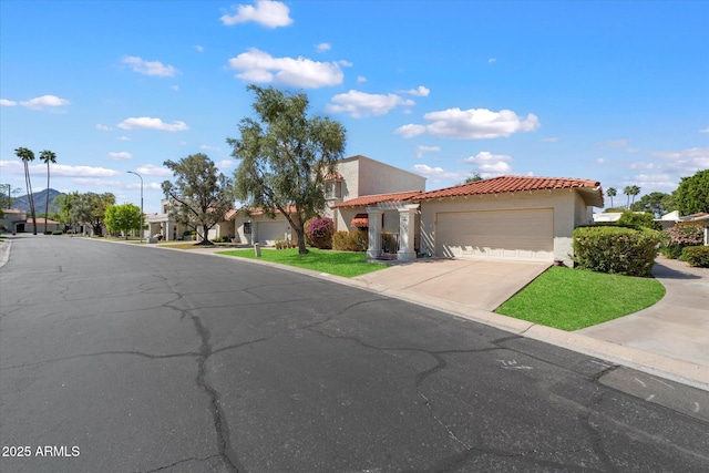 mediterranean / spanish home featuring driveway, stucco siding, an attached garage, and a tile roof