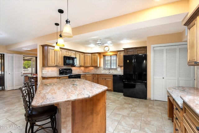 kitchen with light stone countertops, a kitchen bar, black appliances, and decorative backsplash