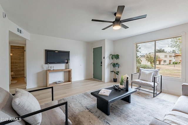 living area featuring ceiling fan, visible vents, baseboards, and light wood-style flooring