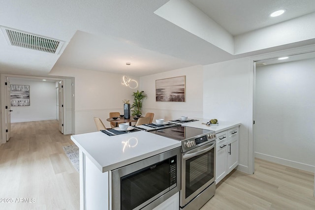 kitchen with visible vents, light wood-style flooring, stainless steel electric stove, white cabinetry, and built in microwave