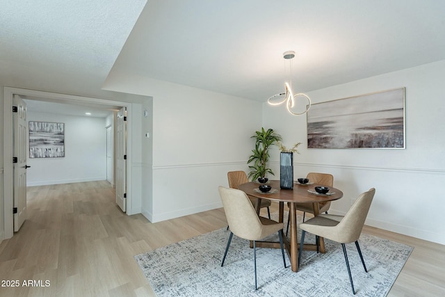 dining room with light wood-type flooring and baseboards