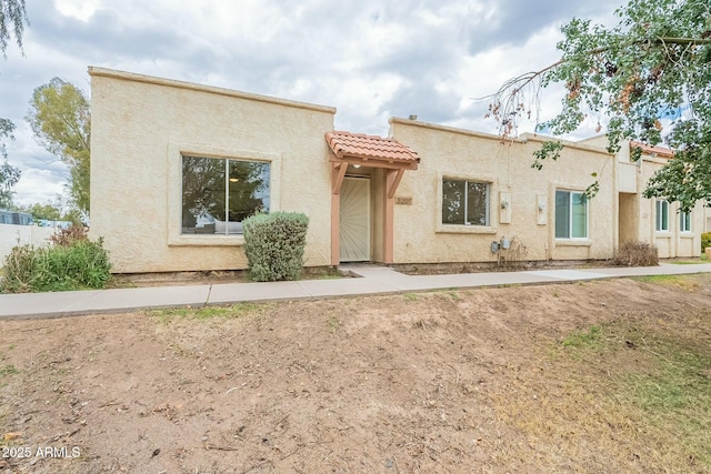 mediterranean / spanish house featuring a tiled roof and stucco siding