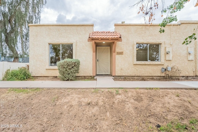 view of front facade featuring stucco siding and a tile roof