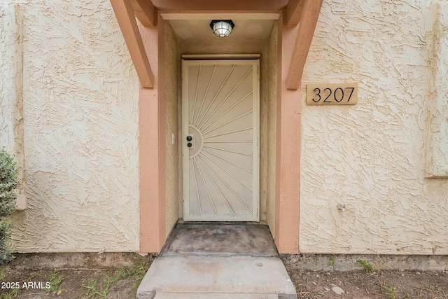 entrance to property with stucco siding