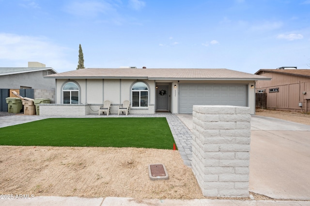 view of front of property with stucco siding, driveway, an attached garage, and a front lawn