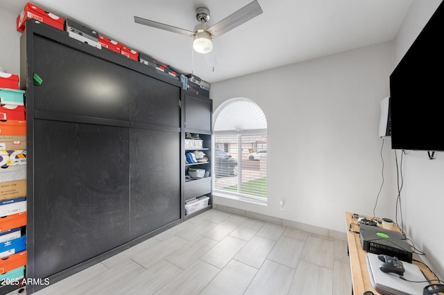 interior space with baseboards and ceiling fan