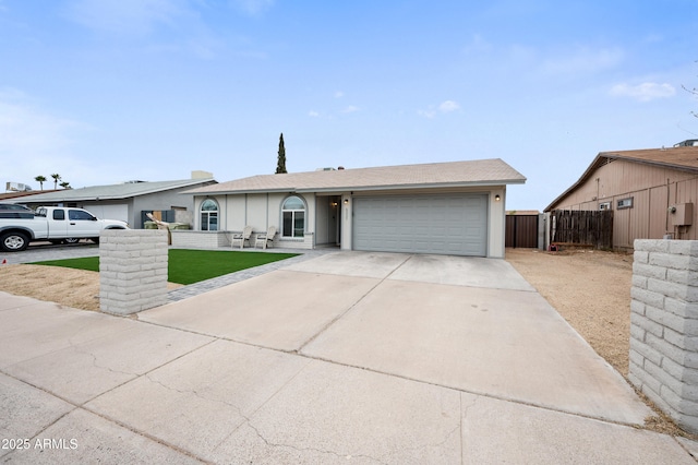 ranch-style house featuring an attached garage, driveway, and fence