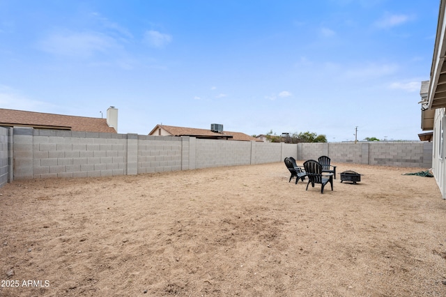 view of yard with a fenced backyard and a fire pit