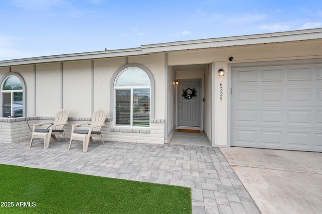 property entrance featuring concrete driveway and an attached garage