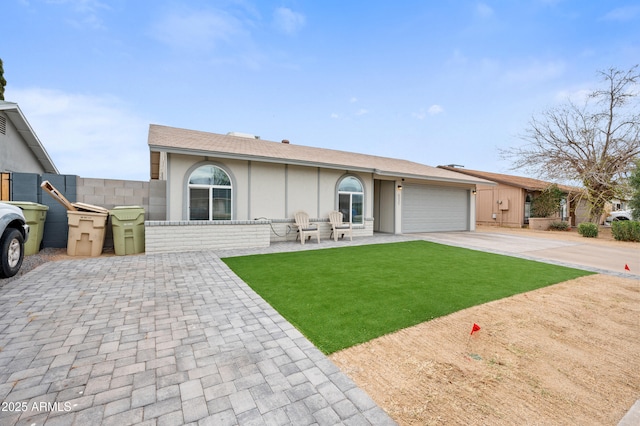 view of front of property featuring stucco siding, an attached garage, concrete driveway, and a front yard