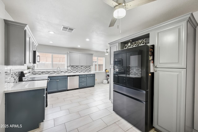 kitchen featuring tasteful backsplash, visible vents, stainless steel appliances, and a ceiling fan