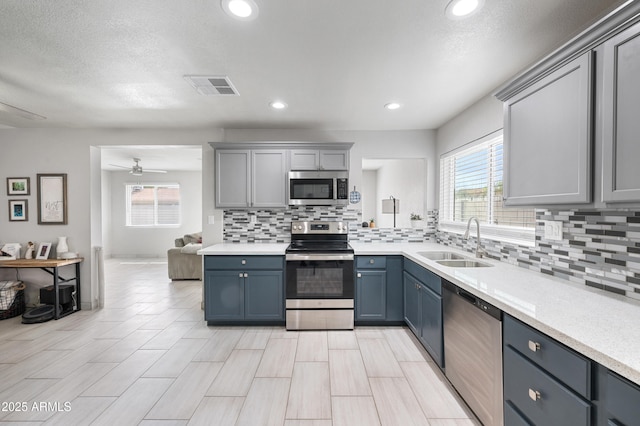 kitchen with a sink, stainless steel appliances, visible vents, and light countertops