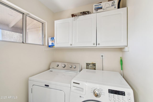 washroom featuring washing machine and dryer and cabinet space