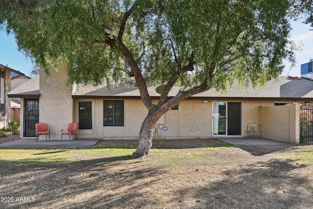 back of house with a patio, fence, roof with shingles, a lawn, and stucco siding