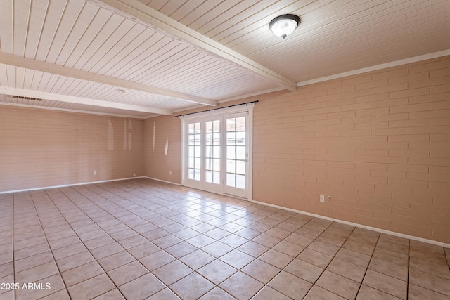 unfurnished room featuring brick wall, light tile patterned floors, and beam ceiling