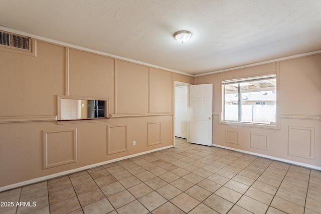 empty room featuring ornamental molding and a textured ceiling