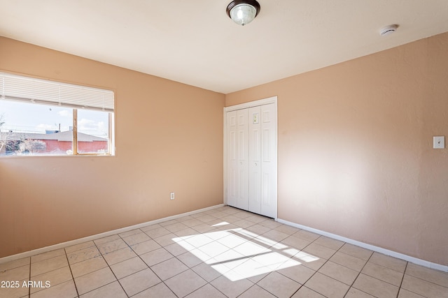 unfurnished bedroom featuring light tile patterned floors and a closet