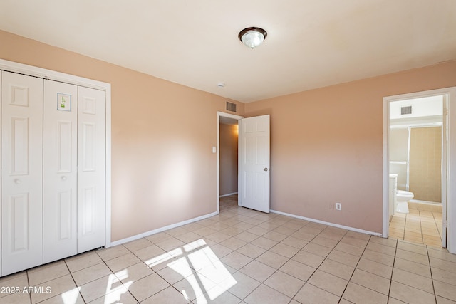 unfurnished bedroom featuring light tile patterned floors and a closet