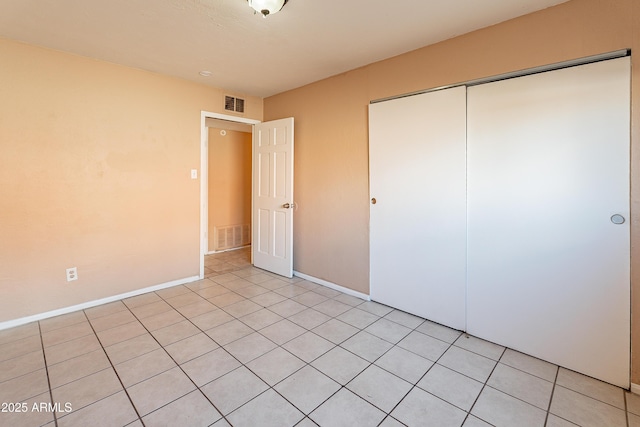 unfurnished bedroom featuring light tile patterned floors and a closet