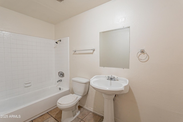 bathroom with tiled shower / bath combo, tile patterned floors, and toilet