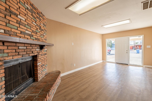 unfurnished living room with hardwood / wood-style floors and a fireplace