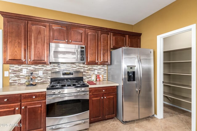 kitchen with light tile patterned floors, tasteful backsplash, stainless steel appliances, and light countertops