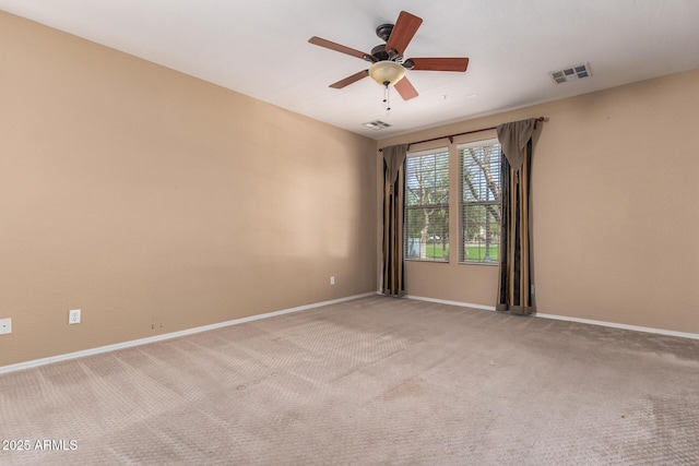 empty room featuring baseboards, ceiling fan, visible vents, and light colored carpet