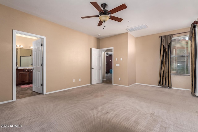 unfurnished bedroom with baseboards, visible vents, carpet flooring, and ensuite bathroom