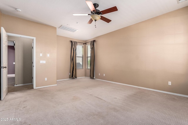 spare room featuring a ceiling fan, visible vents, light carpet, and baseboards