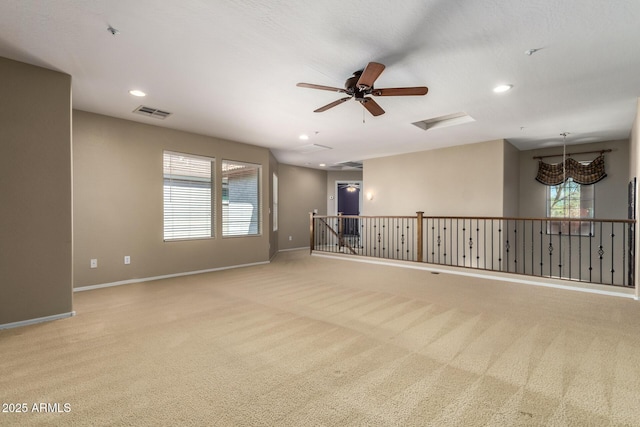 empty room featuring light carpet, visible vents, baseboards, and recessed lighting