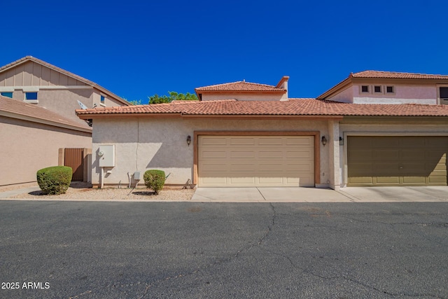 view of front of home with a tile roof, an attached garage, and stucco siding