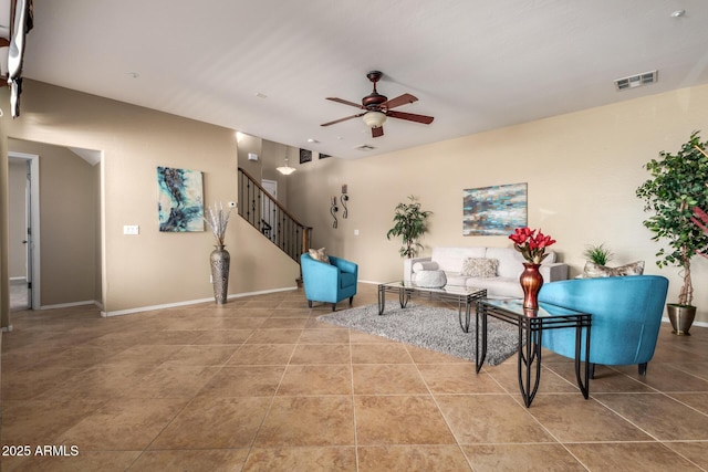 living area with stairs, visible vents, ceiling fan, baseboards, and tile patterned floors