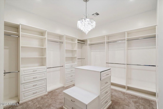 spacious closet featuring visible vents, light colored carpet, and a chandelier