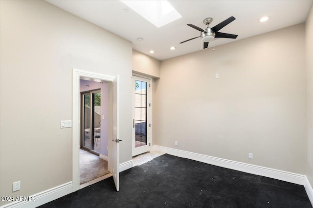 spare room with recessed lighting, a skylight, and baseboards