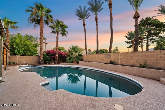 pool at dusk with a fenced in pool, a fenced backyard, and a patio area