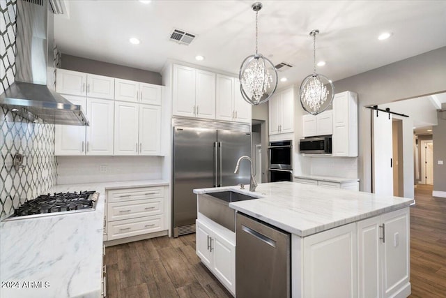 kitchen with visible vents, dark wood-type flooring, wall chimney range hood, white cabinets, and stainless steel appliances