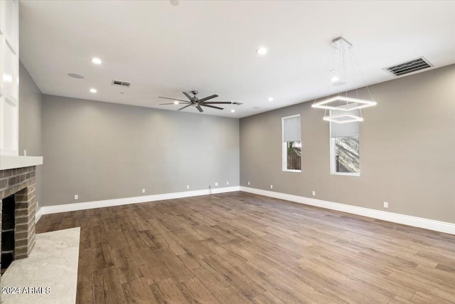 unfurnished living room with visible vents, baseboards, and wood finished floors