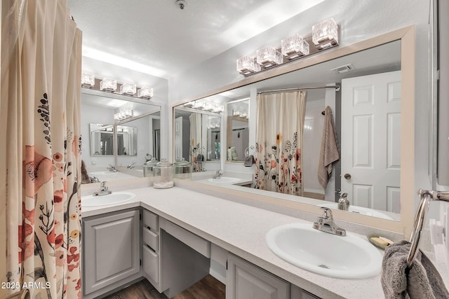 bathroom featuring double vanity, a shower with curtain, and a sink