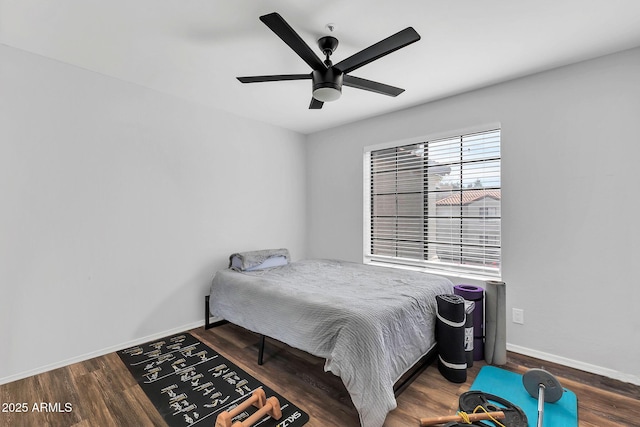 bedroom with ceiling fan, baseboards, and wood finished floors